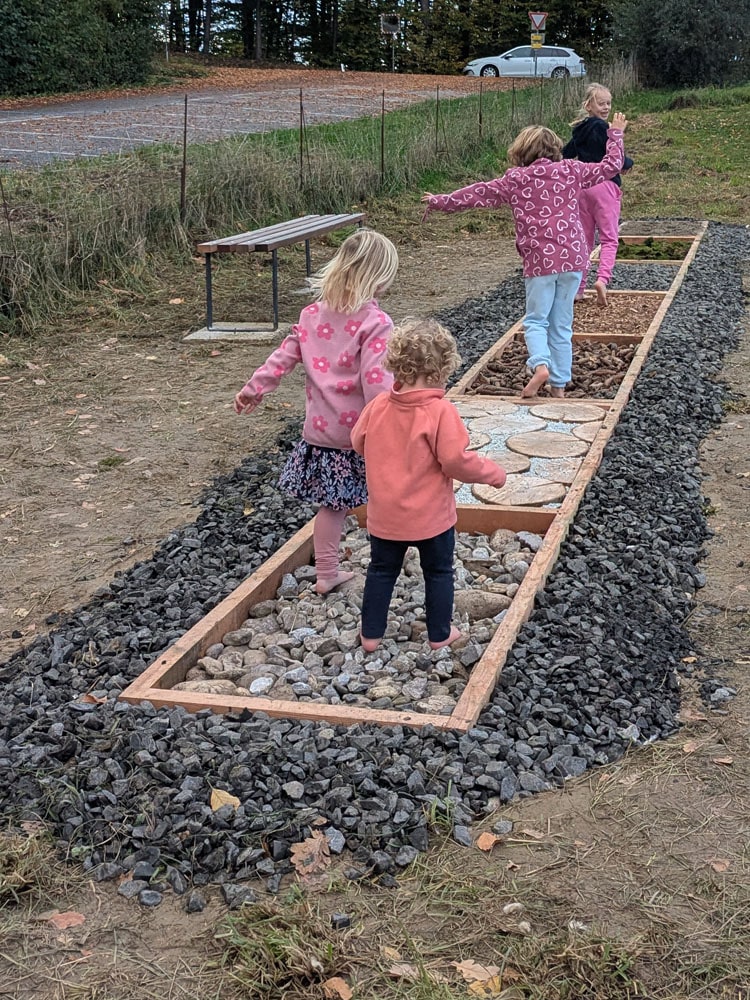 Die Nachbarskinder testen den neuen Barfußweg im Haus der Stille
